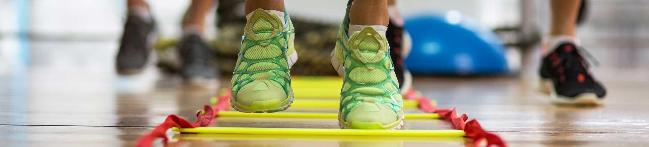 Tennis shoes running through a fitness ladder