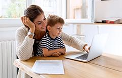 Mother with child in her lap looking at laptop